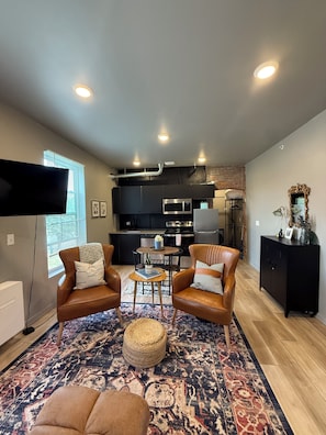 Uma sala de estar moderna com poltronas de couro, uma mesa de centro e um tapete estampado.