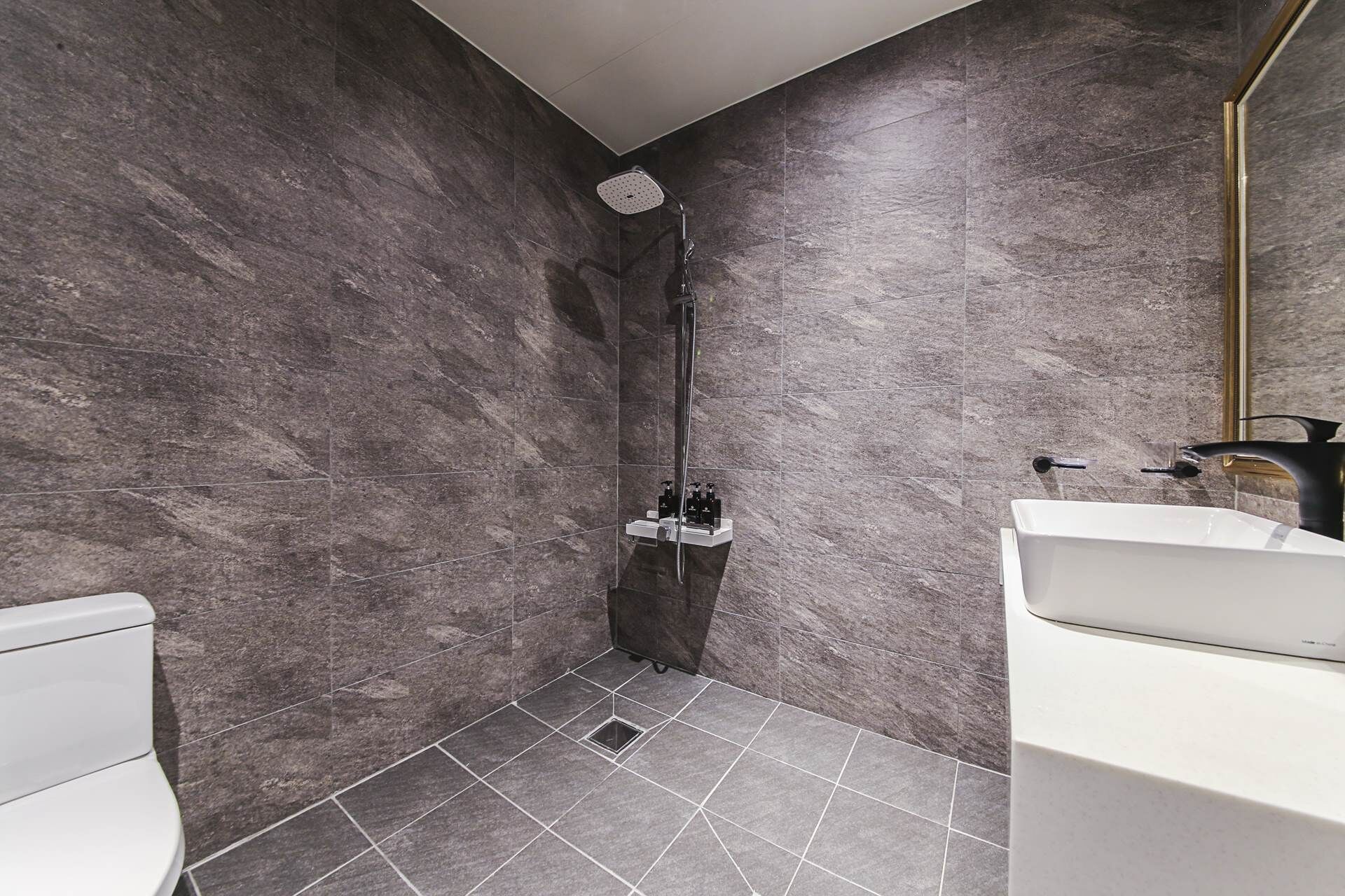 Un baño moderno con ducha, inodoro y lavamanos.