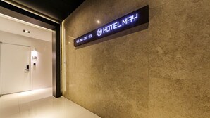 Interno moderno di un hotel con un cartello che indica i numeri delle stanze da 201 a 207.