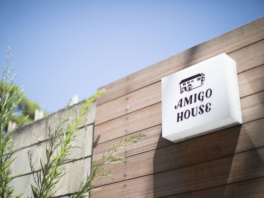 A sign with the text "AMIGO HOUSE" and a small building illustration.