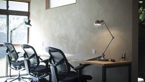 A workspace with two black office chairs, a desk, and a single desk lamp. - AMIGO HOUSE - Hostel (Zushi)