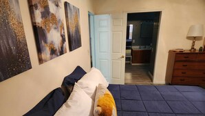 A bedroom with a bed, pillows, and a plush toy. There is a door leading to a hallway and a room with a mirror. - Sleeps up to 8 in a safe, quiet area (Kodak)