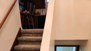 A carpeted staircase leading to a lower level with a door at the bottom. - Sleeps up to 8 in a safe, quiet area (Kodak)