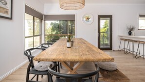 Un'ampia sala da pranzo con un tavolo in legno, sedie e un lampadario.