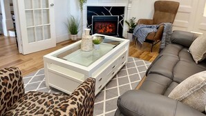 A living room with a fireplace, a television, and a sofa. - Boston Hospitality Homes, Harvard (Boston)