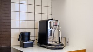 A kitchen with a coffee maker, a kettle, and a toaster on a countertop. - Coastal Escape - Freycinet Holiday Houses (Coles Bay)
