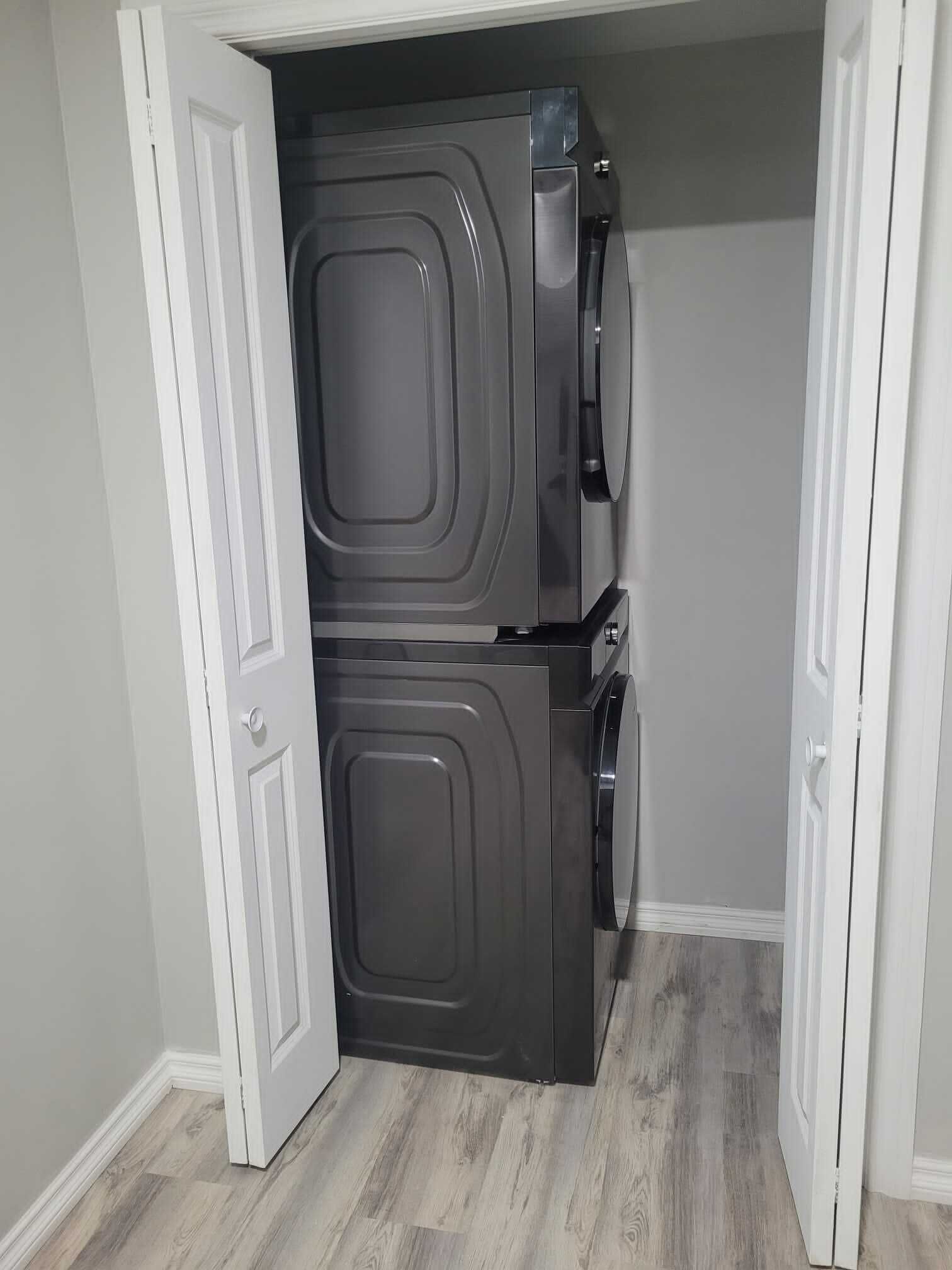 A compact, modern closet with a double door, built-in shelves, and a hanging rod.