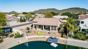 A residential property with a swimming pool, a patio area with chairs, and a view of a hilly landscape. - Lakefront Oasis (Glendale)