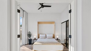 A modern bedroom with a large bed, a ceiling fan, and a view through the window. - Lakefront Oasis (Glendale)