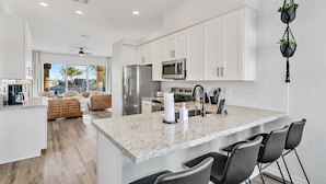 A modern kitchen with white cabinets, stainless steel appliances, and a granite countertop. - Lakefront Oasis (Glendale)