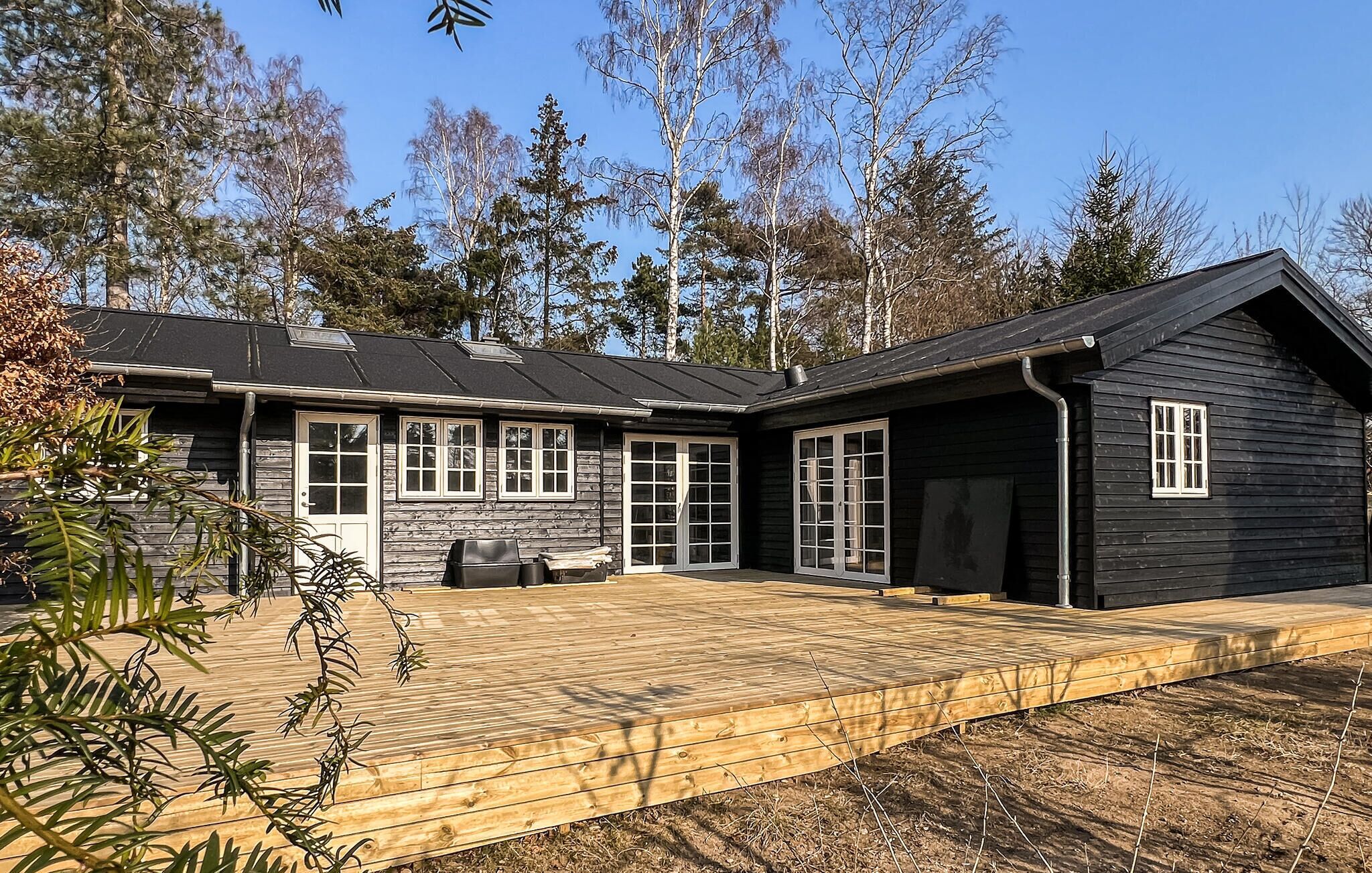 Een houten blokhut met twee verdiepingen, een terras en een garage.