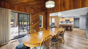 Un comedor espacioso con mesa y sillas de madera, una cocina con electrodomésticos modernos y vistas al exterior.