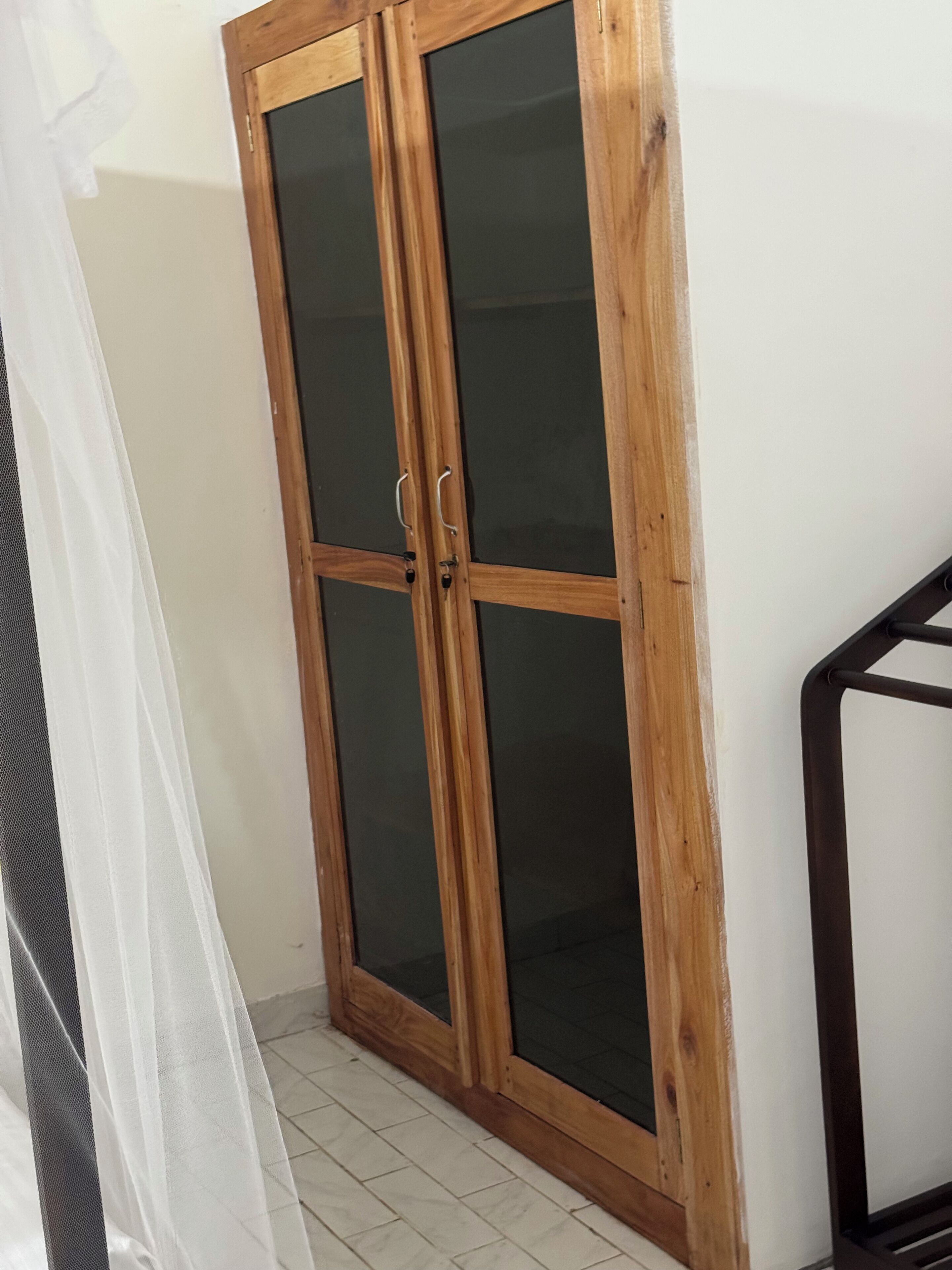 Una puerta de madera con paneles de vidrio y un pomo de metal.