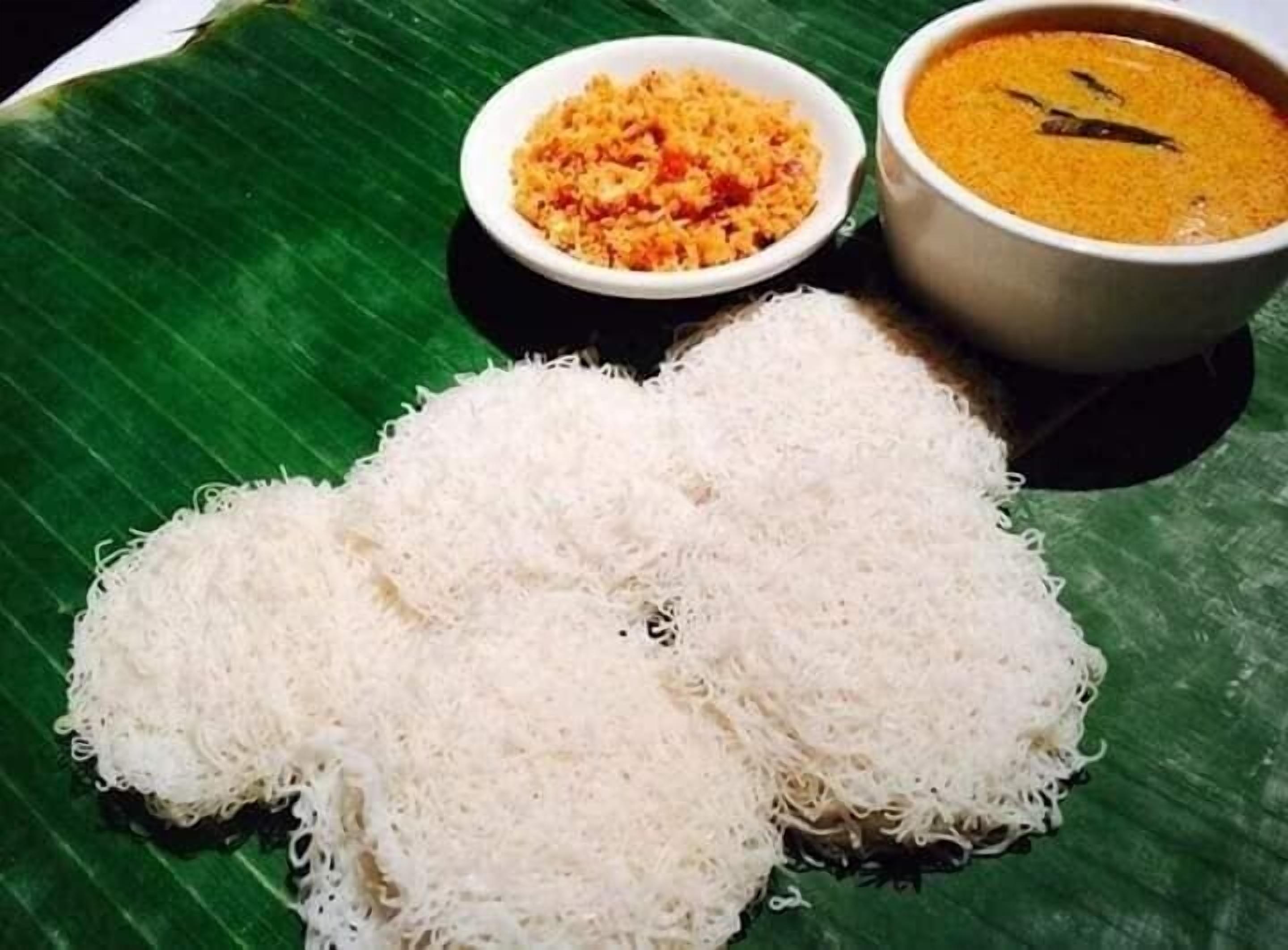Un plato de idli acompañado de un tazón de chutney y sambar.