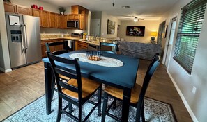 A kitchen with a dining table, chairs, and a refrigerator. - Quiet getaway on a hidden Spring-run (Spring Hill)