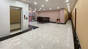A spacious lobby with a marble floor, a reception desk, and a staircase leading to an upper floor. - NEW LAND Apartment - Nam Thong 3  (Ho Chi Minh City)