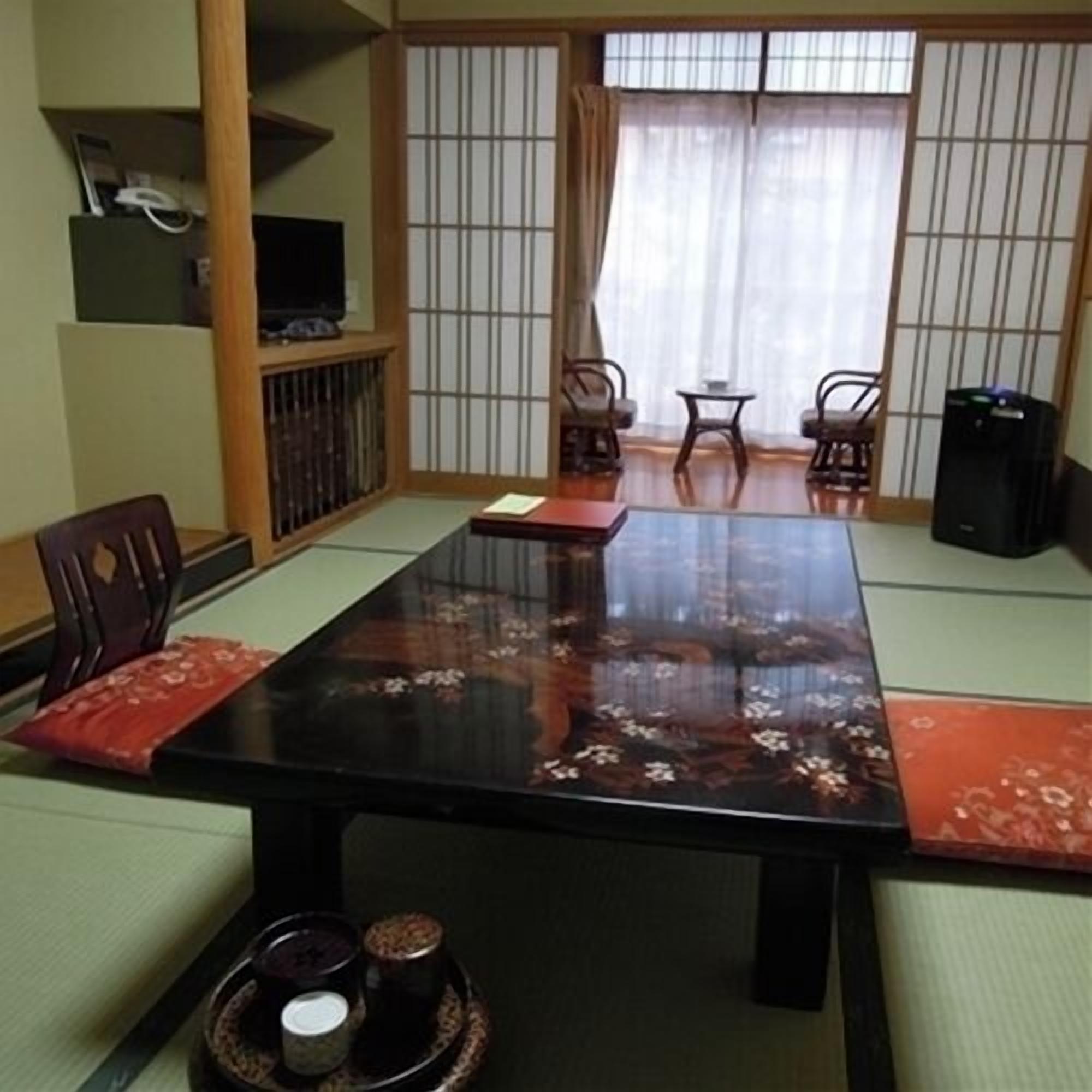 A traditional Japanese-style room with tatami flooring, a low table, and shoji screens.