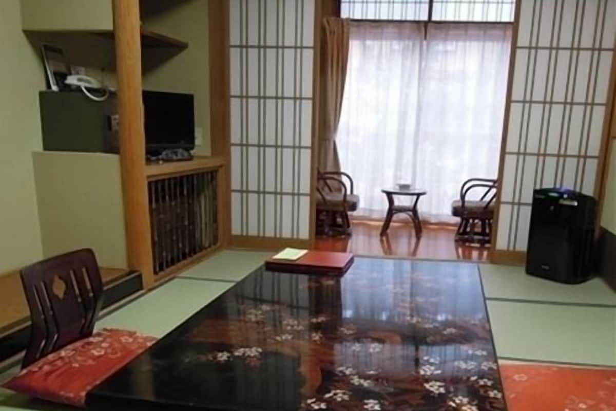 A traditional Japanese-style room with tatami flooring, a low table, and shoji screens.