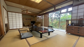 Une pièce de style japonais traditionnel, avec un sol recouvert de tatamis, une table basse et des portes coulissantes.