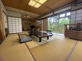 Una habitación tradicional japonesa con suelo de tatami, una mesa baja y puertas correderas.