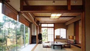 Une pièce de style japonais traditionnel, avec un sol recouvert de tatamis, une table basse et des portes coulissantes.