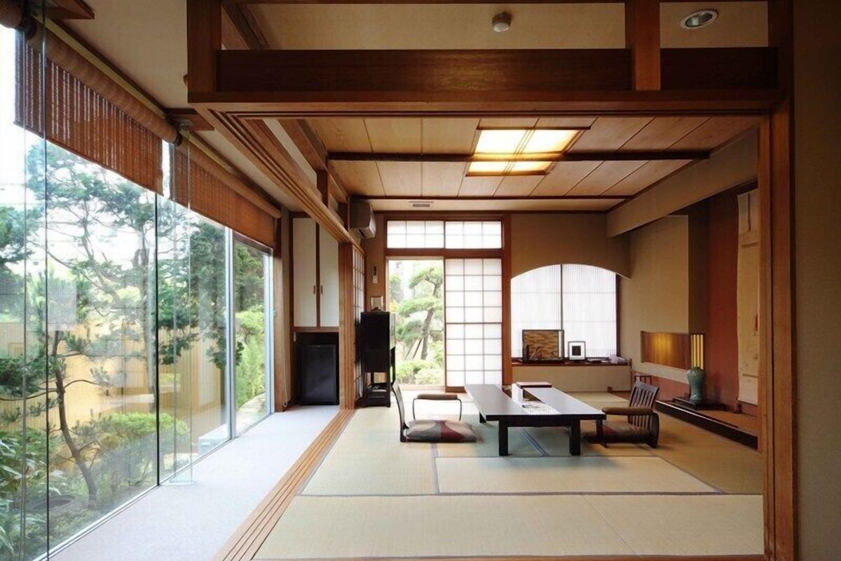 Ein traditioneller japanischer Raum mit Tatami-Böden, einem niedrigen Tisch und Schiebetüren.