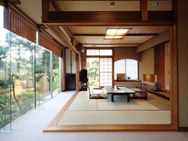 Una habitación japonesa tradicional con suelo de tatami, una mesa baja y puertas correderas.
