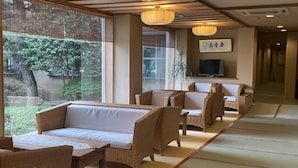 Une pièce de style japonais traditionnel, avec un sol recouvert de tatamis, une table basse et un canapé.