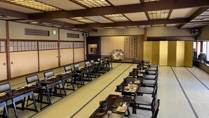 Une pièce de style japonais traditionnel, avec des tatamis, de petites tables basses et des chaises.