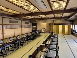 Una habitación tradicional japonesa con esteras de tatami, mesas bajas y sillas.