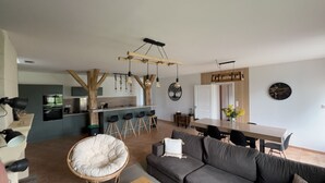 A modern kitchen with a central island, bar stools, and pendant lighting. - Chez FLO et Marjo des Séjours a la Campagne Repos Assurer (Gageac-et-Rouillac)
