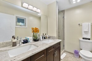 A modern bathroom with dual sinks, a large mirror, and a shower area. - Vista Villa (Scottsdale)