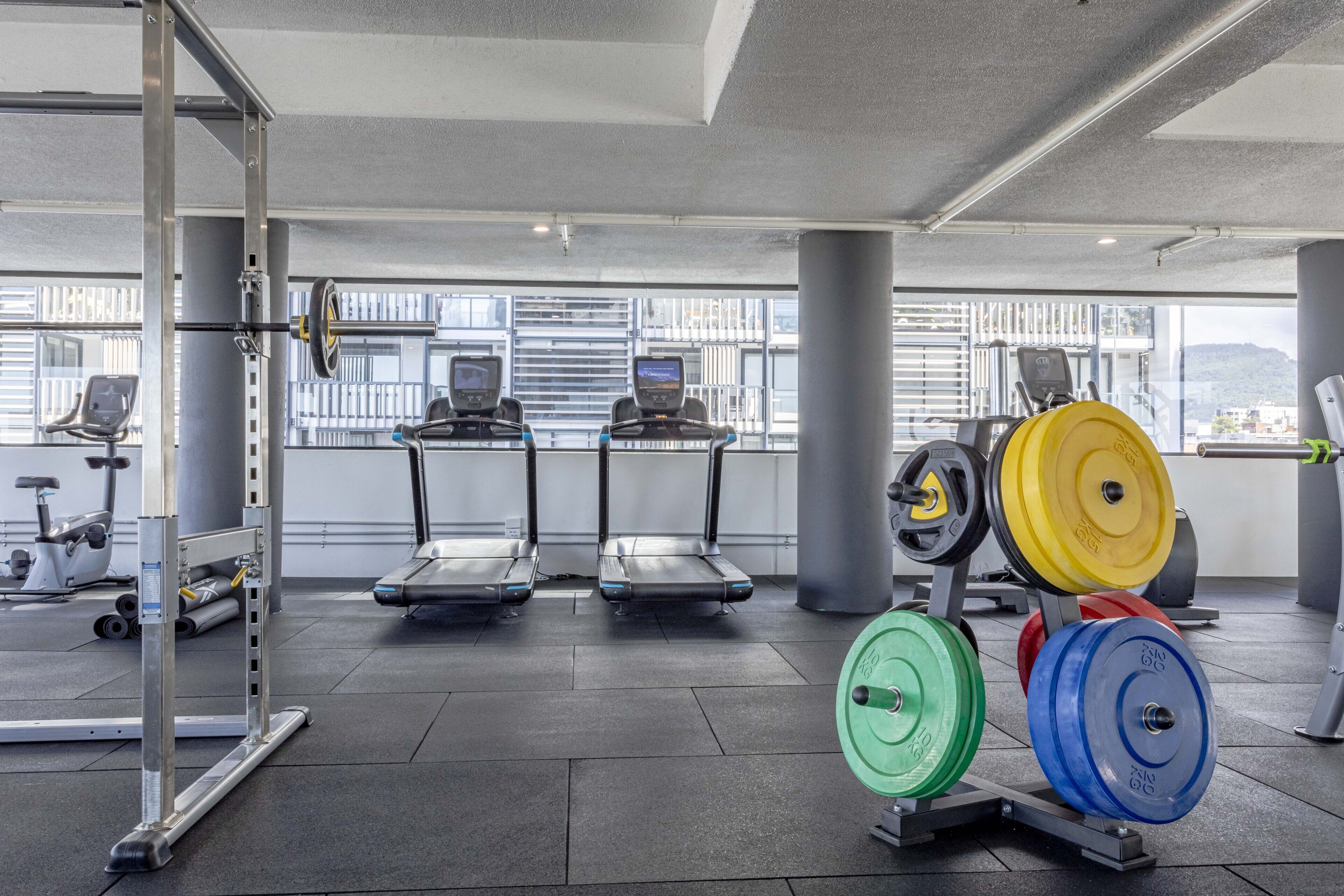 A gym with treadmills, weightlifting equipment, and exercise machines.