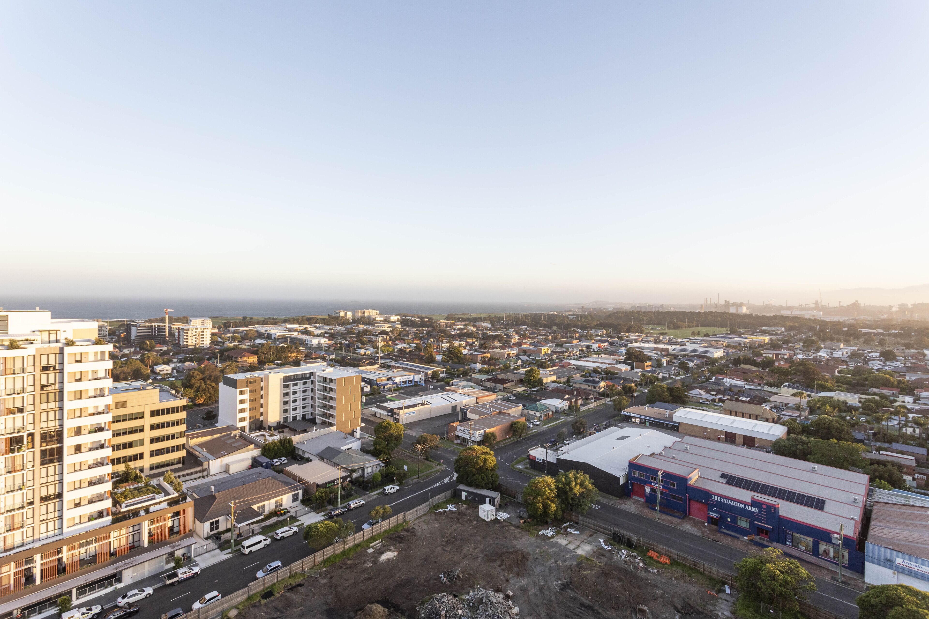 An aerial view of a cityscape with various buildings, roads, and a large industrial area.