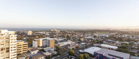 An aerial view of a cityscape with various buildings, roads, and a large industrial area.