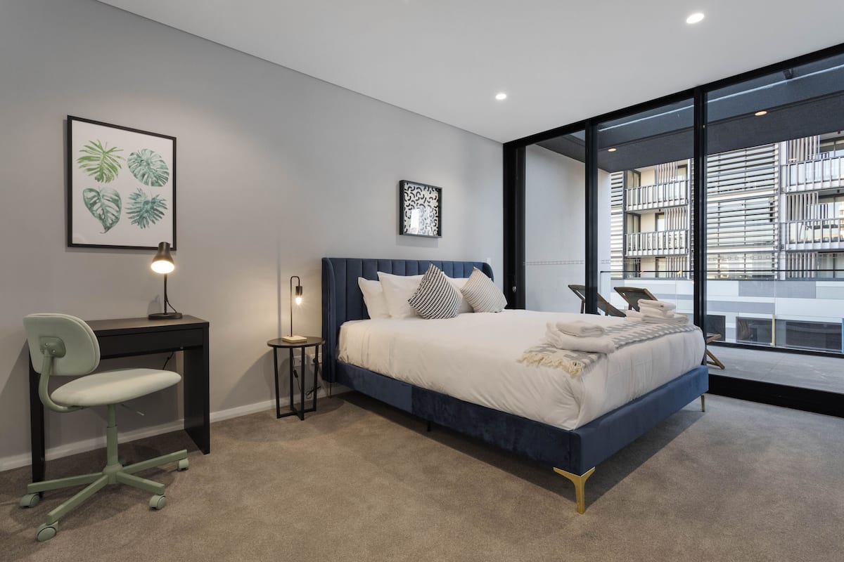 Un dormitorio moderno con una cama grande, un escritorio y una silla.