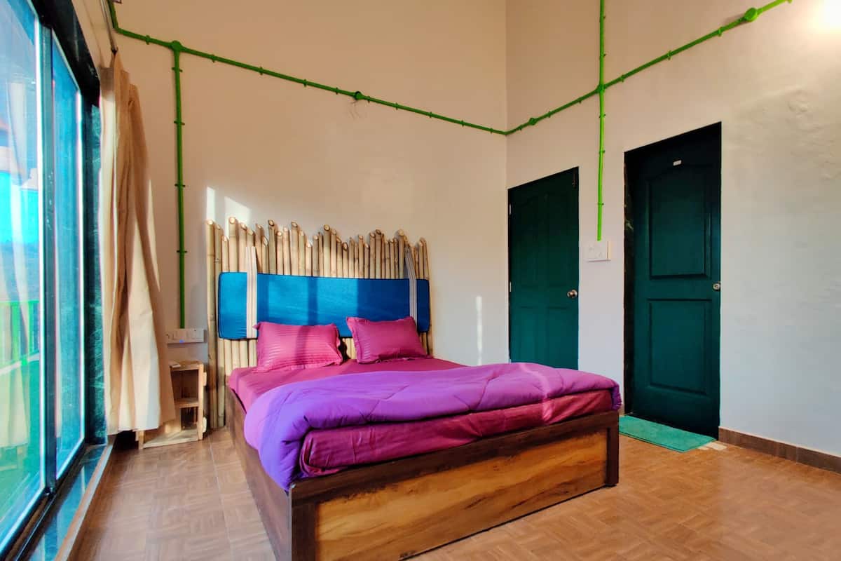 A bedroom with a wooden bed, a blue headboard, and a green door.