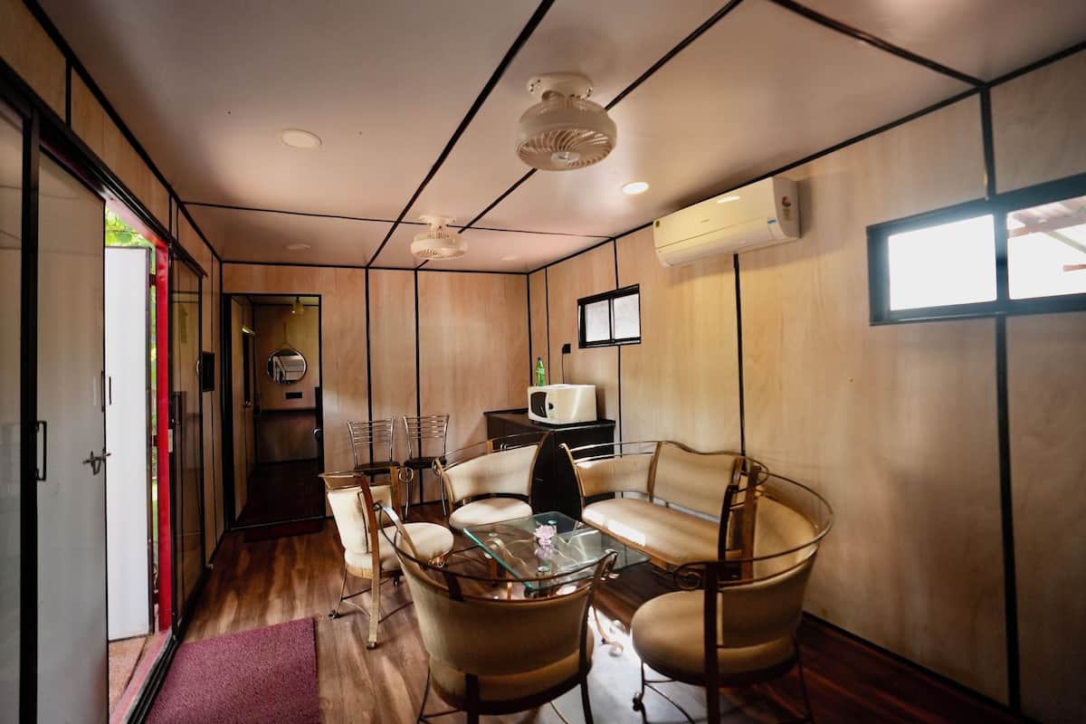 A modern interior with a glass table, leather chairs, and a wooden floor.