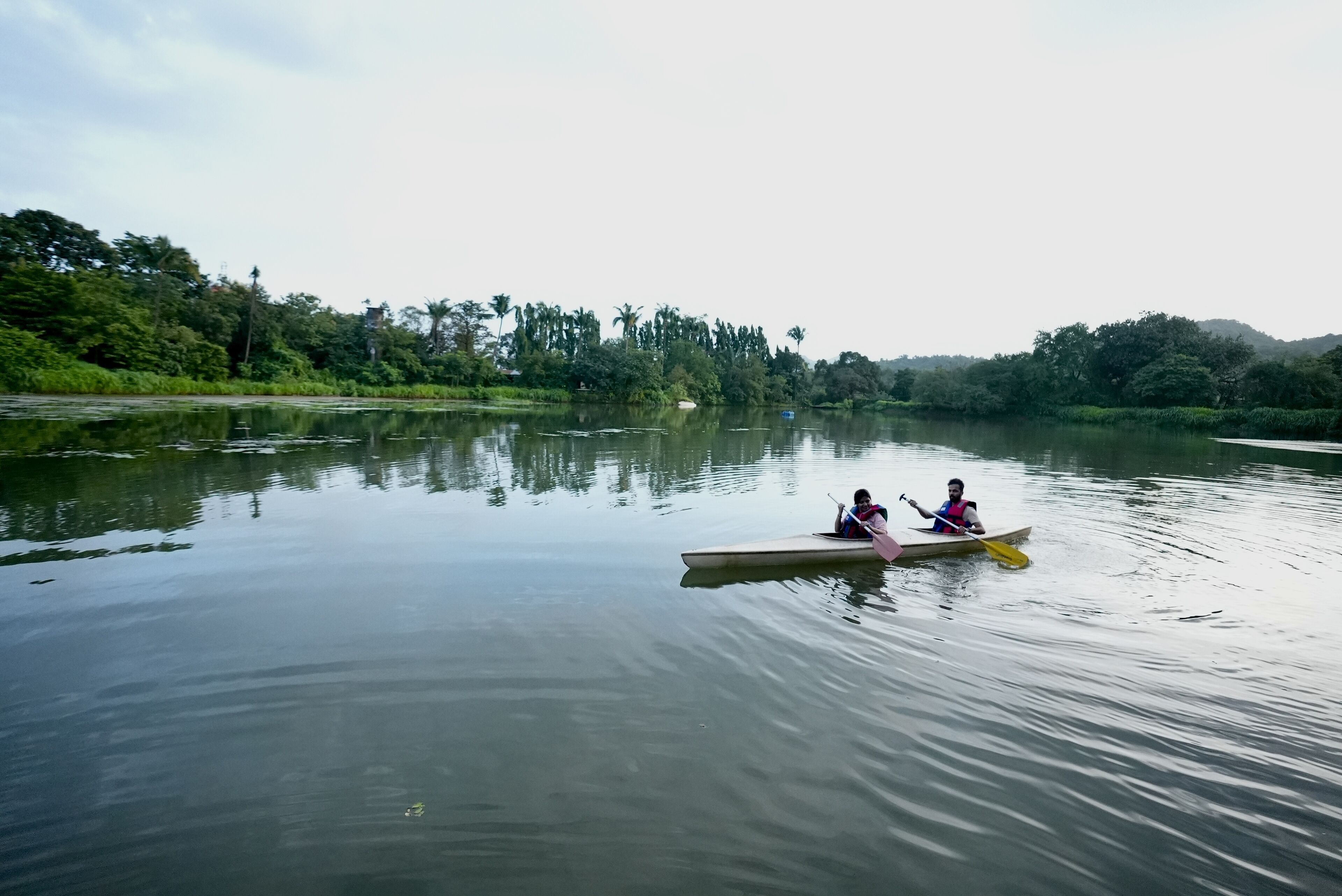 A calm river with a canoe carrying two people.