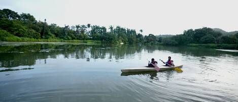 A calm river with a canoe carrying two people.