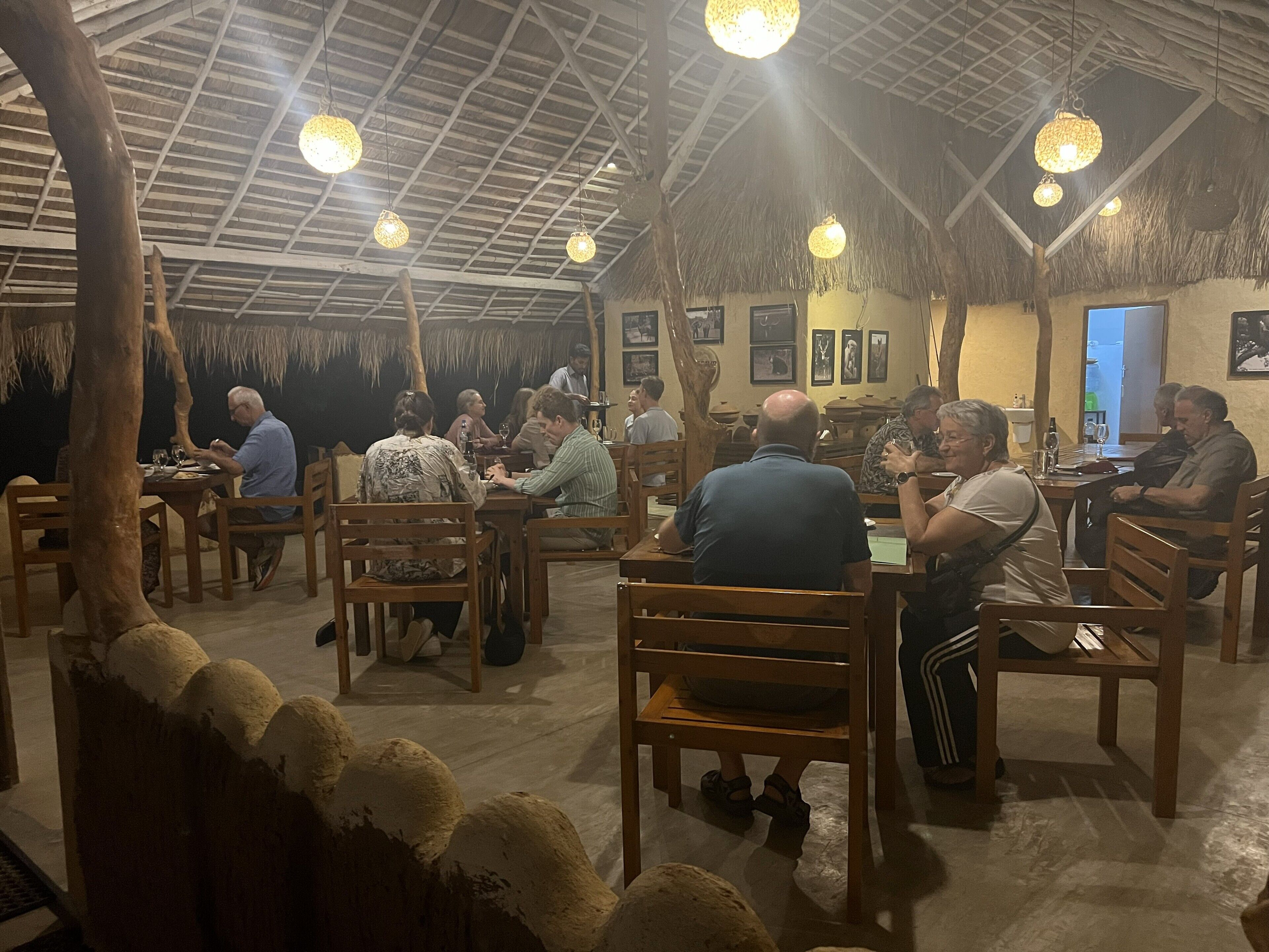 A restaurant with wooden furniture and hanging lights.