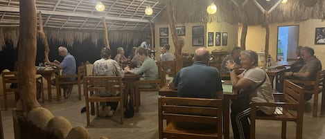 A restaurant with wooden furniture and hanging lights.