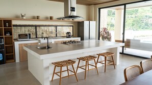 A modern kitchen with a large island, built-in appliances, and a view to the outdoors. -  JadenHill CityView 8BR Villa Heated Pool+Movieroom (Cimenyan)