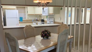 A dining area with a table, chairs, and a chandelier. - Near Beaches! UPDATED! Peaceful Forest Park Condo 2 bd 2 bth. Heat comm pool (Englewood)