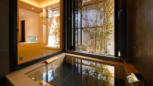 Una moderna hall d'albergo con pavimento in vetro, una reception e vista su un giardino di bambù.
