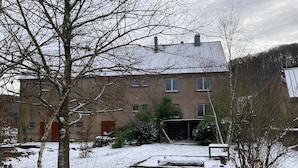 Un bâtiment à deux étages avec une porte rouge et de nombreuses fenêtres.