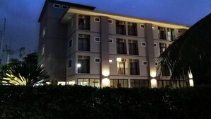 Un hotel de varios pisos con techo plano y múltiples balcones.