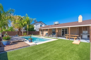 A backyard with a swimming pool, patio furniture, and a barbecue area. - Kristys Kastle (Phoenix)