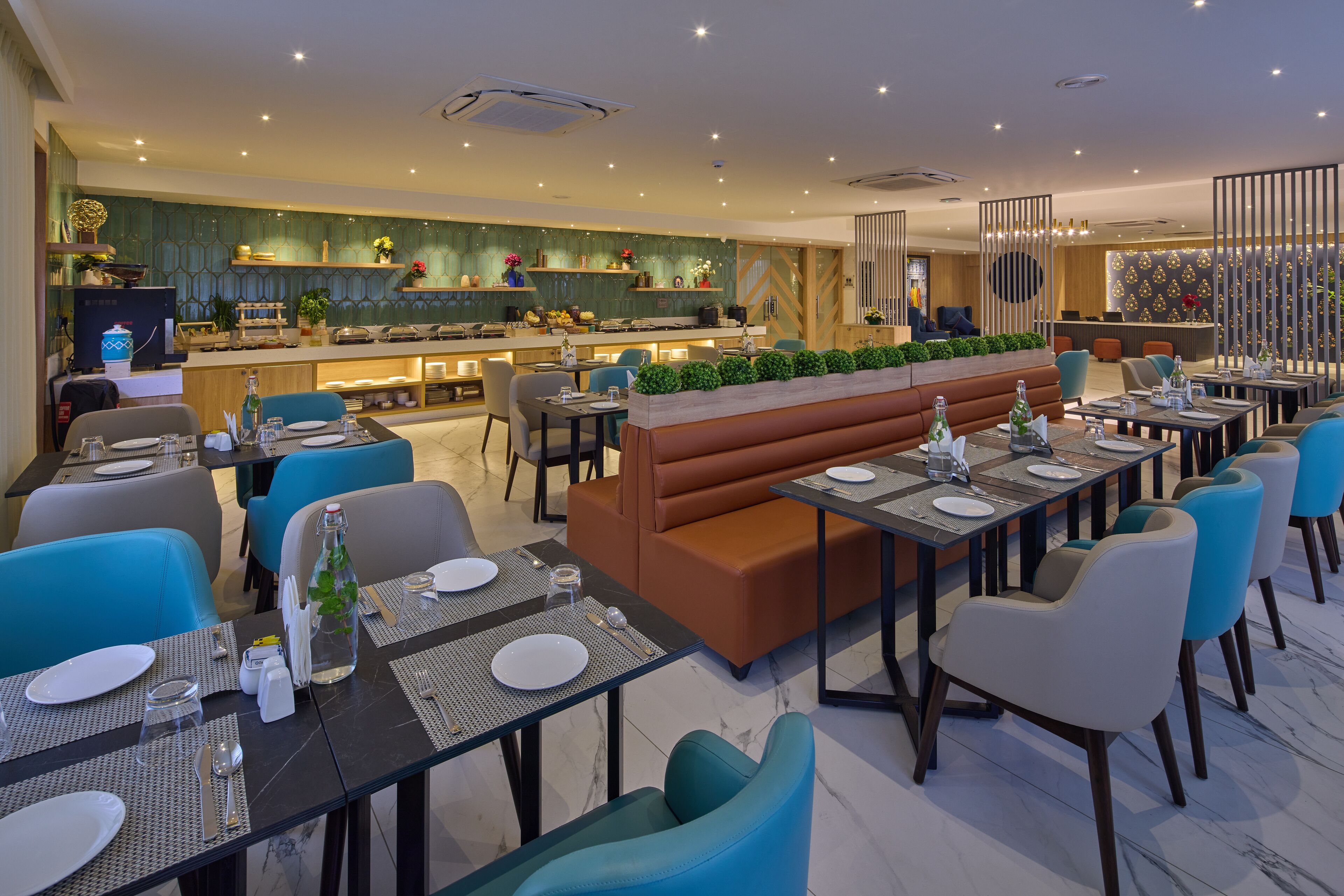 A modern restaurant with a long counter, booths, and a bar area.