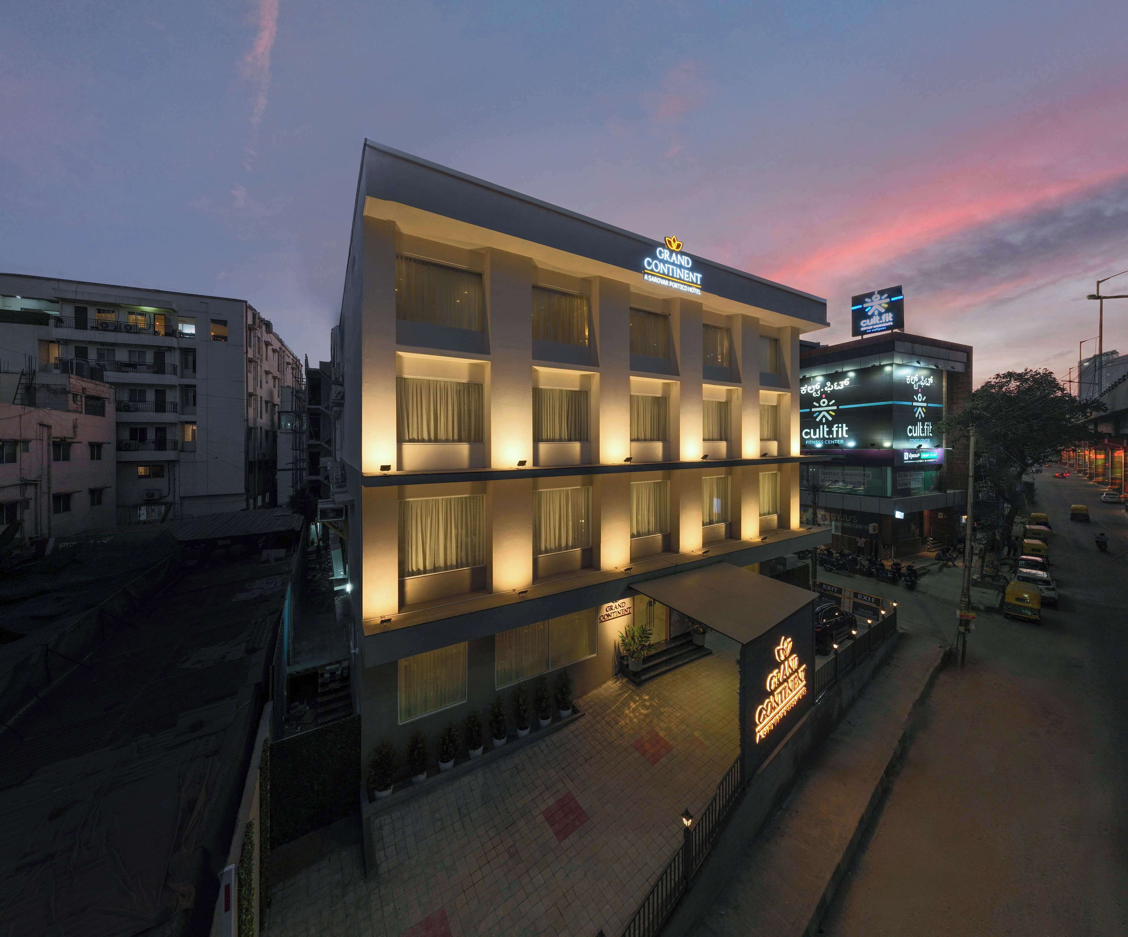 A modern hotel with a prominent sign, multiple floors, and a well-lit facade.